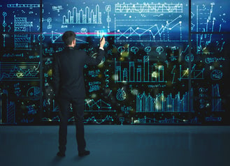 Businessman drawing business statistics on glass wall