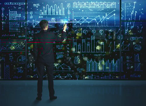 Businessman drawing business statistics on glass wall