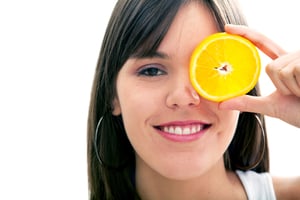 Woman with a slice of orange in her eye isolated